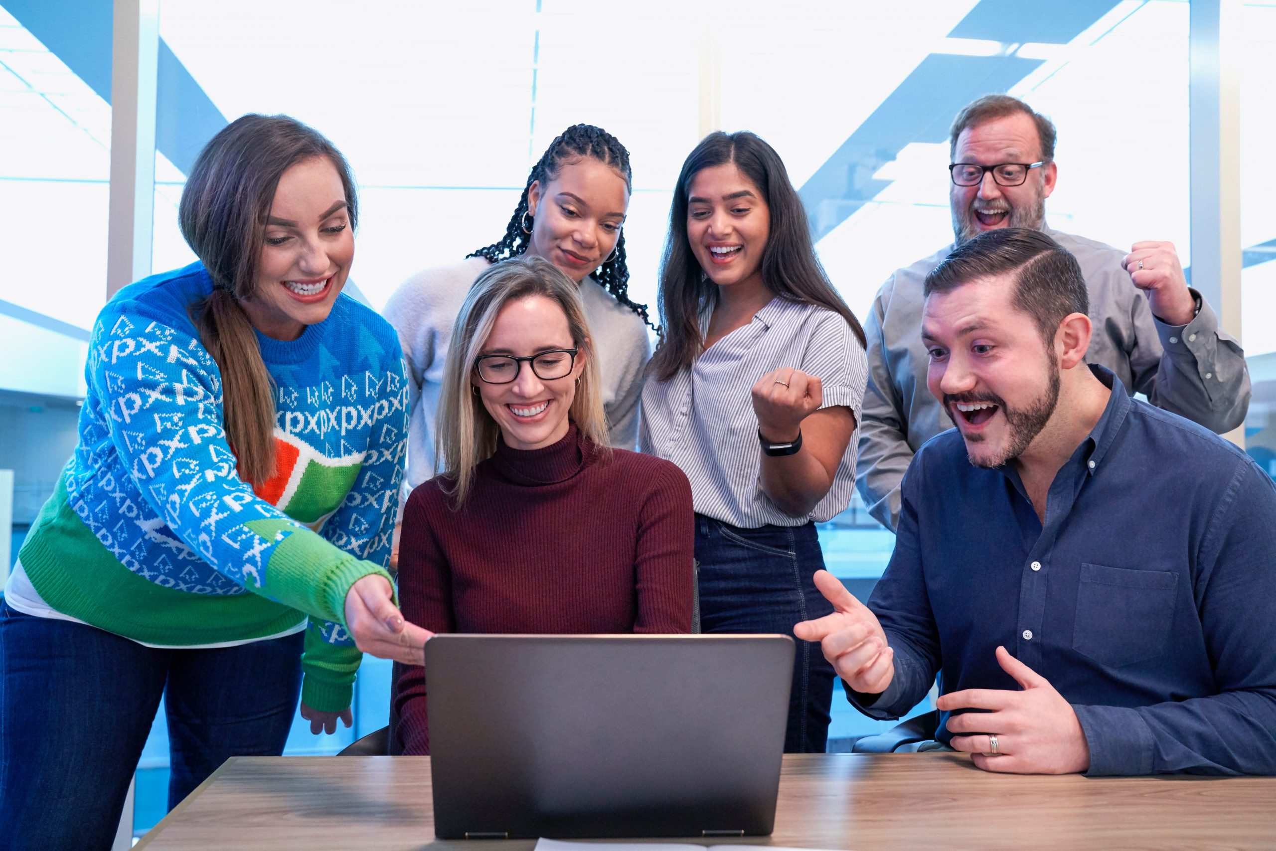 pessoas reunidas na frente de um notebook fazendo networking